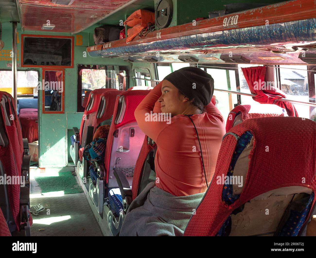 Mochilero femenino sentado dentro de un autobús esperando el autobús para iniciar el viaje. Foto de stock