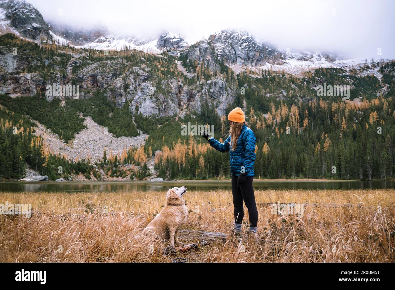 Mujer excursionista y su perro en las montañas de la cascada del norte Foto de stock