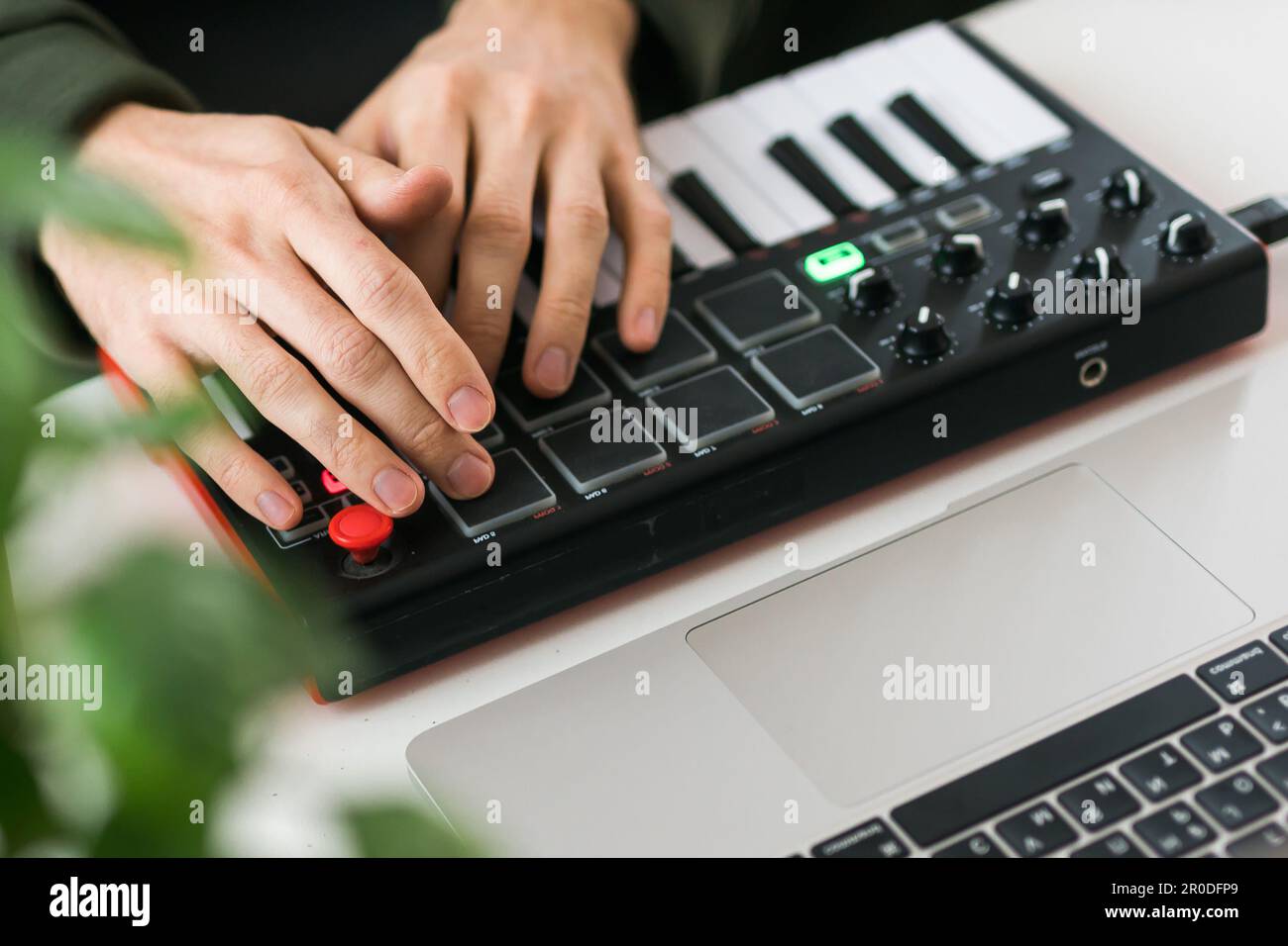 Vista superior del productor o arreglista de música usando el ordenador  portátil y el teclado midi y otros equipos de audio para crear música en el  estudio casero. Batidos y Fotografía de