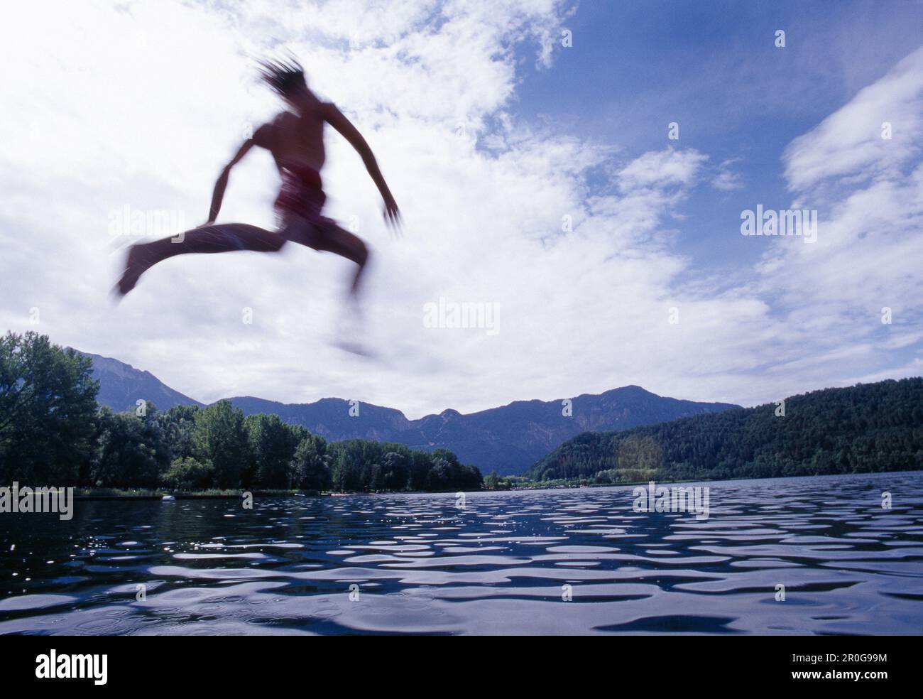 Joven saltando al lago de Levico, Valsugana, Trentino-Alto Adige/Südtirol, Italia Foto de stock
