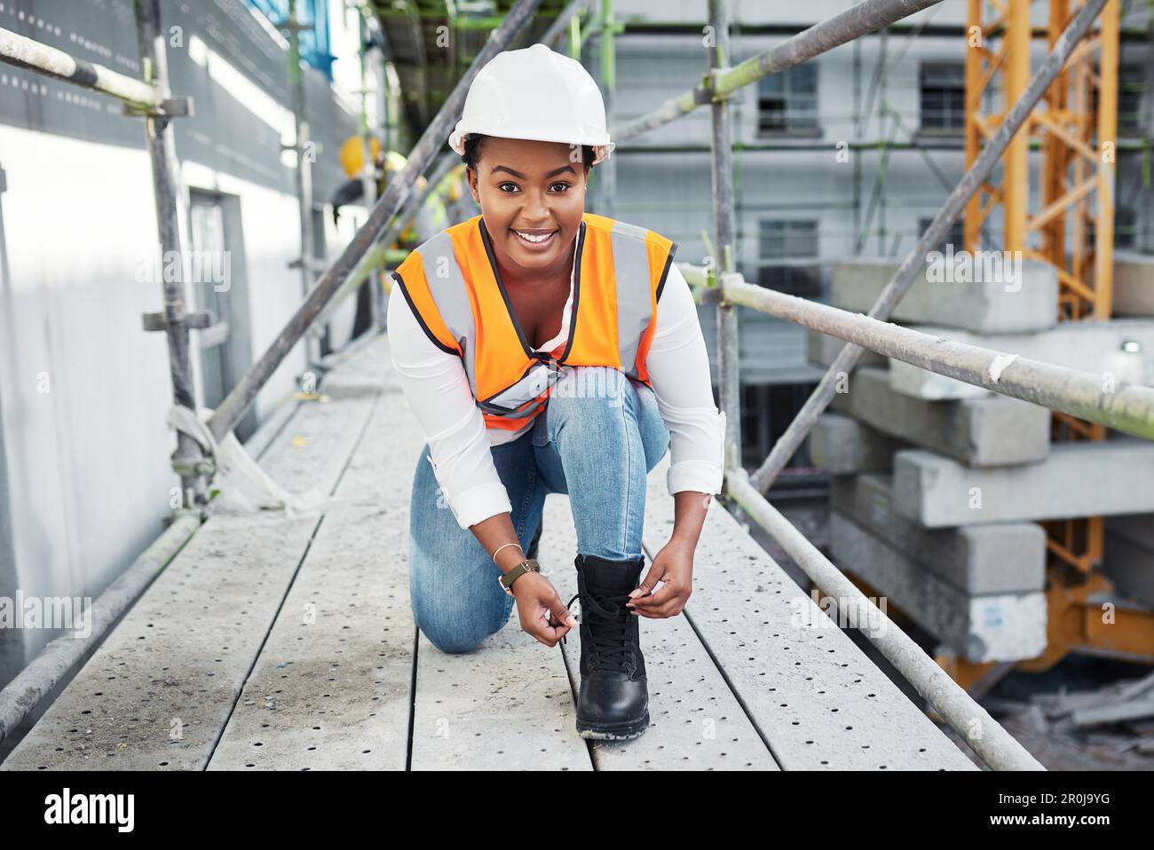 Las botas se ponen, los edificios suben. una mujer joven atando los  cordones de los zapatos en sus botas mientras trabajaba en un sitio de  construcción Fotografía de stock - Alamy