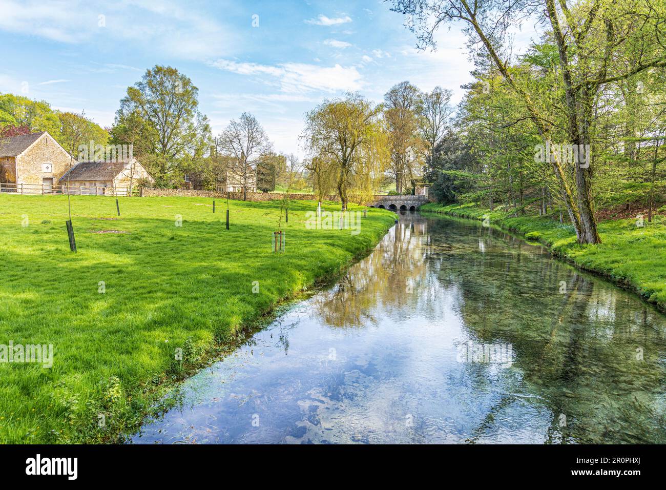 El Sherborne Brook mirando hacia Haycroft Farm & Haycroft House cerca del pueblo Cotswold de Sherborne, Gloucestershire Reino Unido Foto de stock