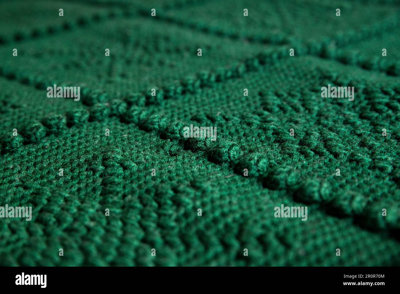 close-up textura de ganchillo verde o manta de punto con un patrón de copo de nieve, fondo Foto de stock