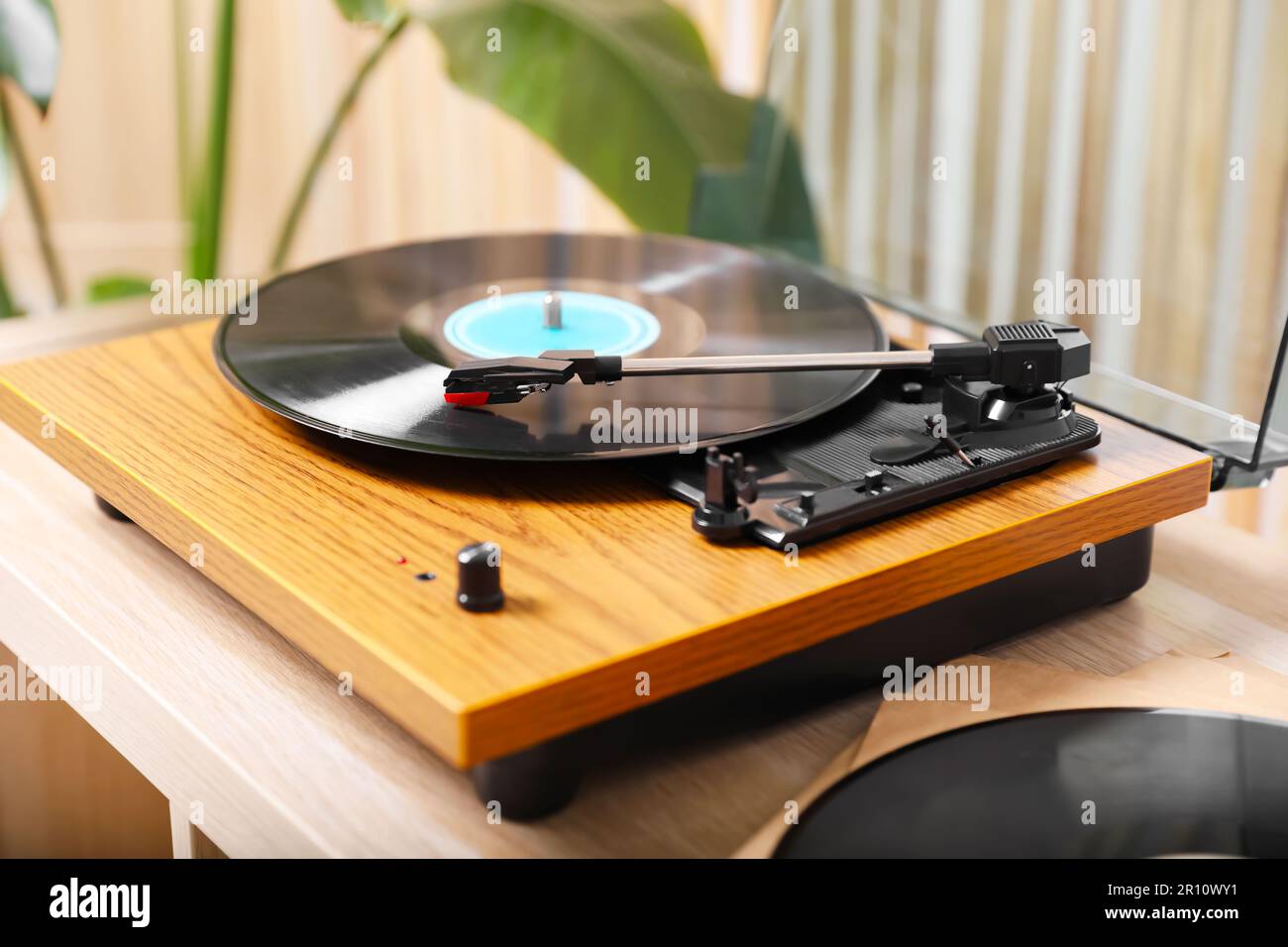 Elegante plato giratorio con disco de vinilo en mesa de madera clara en el  interior Fotografía de stock - Alamy