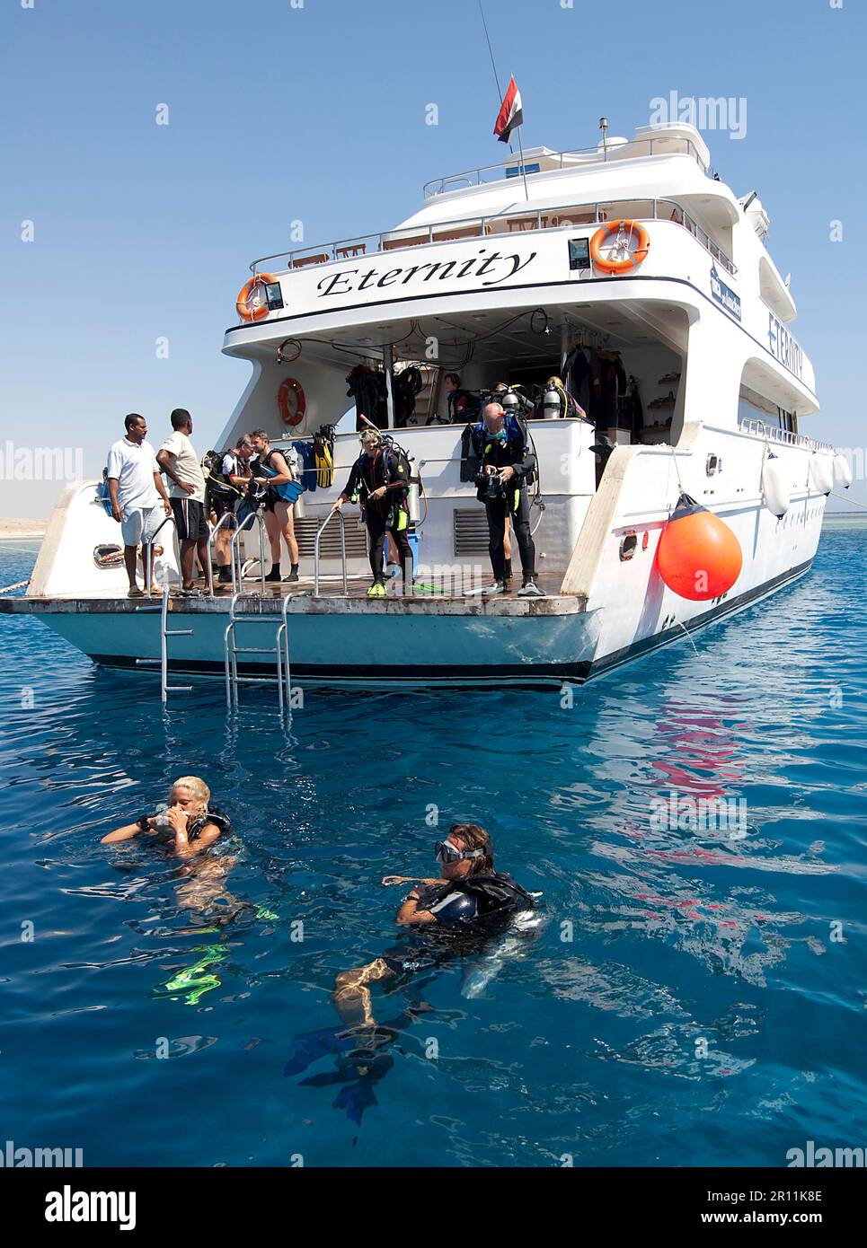 Barco de buceo, buceadores en el agua, plataforma de buceo, Egipto, Mar Rojo Foto de stock