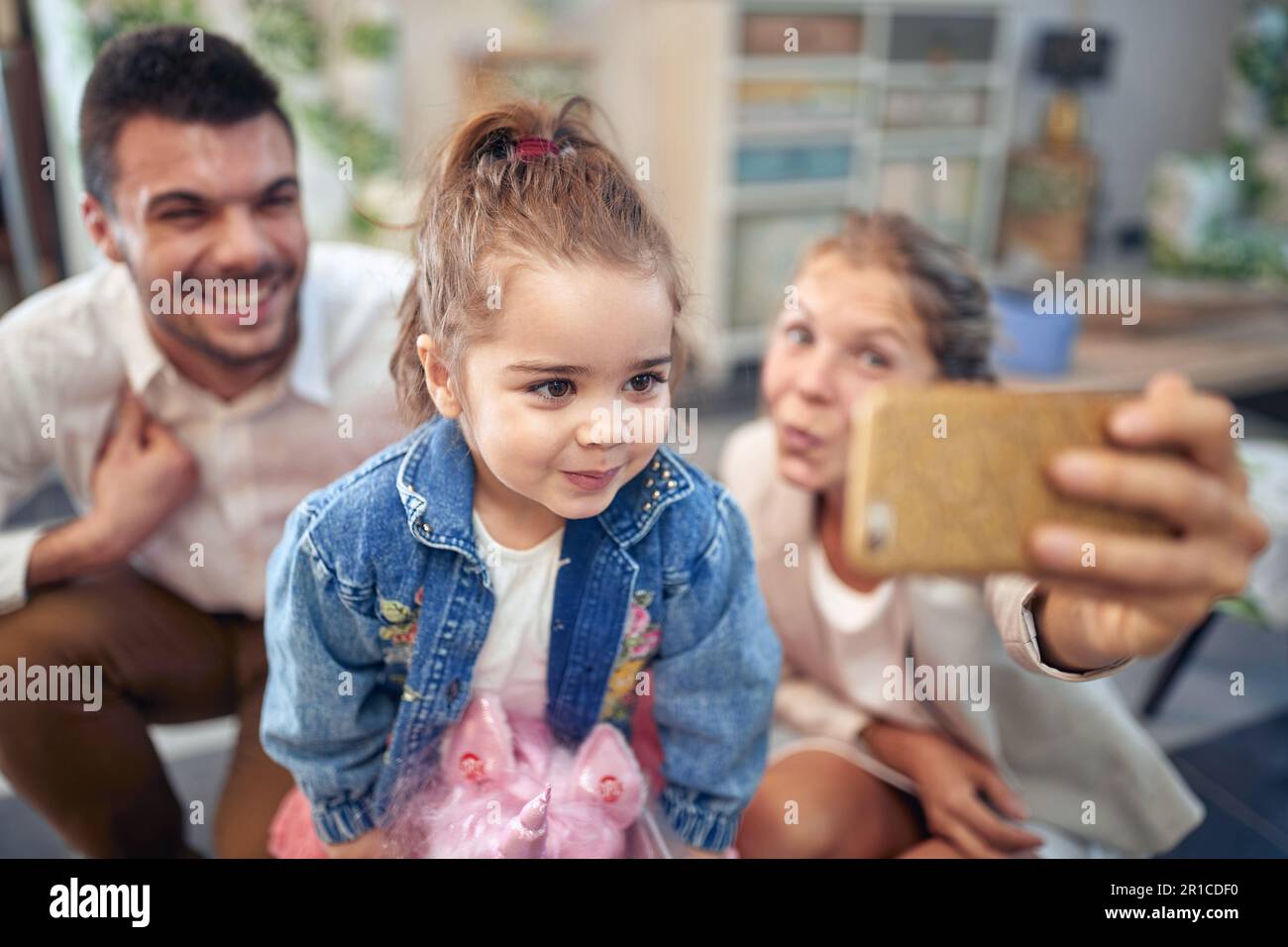 El momento especial de la familia de tomar una selfie juntos. Madre, padre y su hija, están juntos con grandes sonrisas en sus rostros. El mothe Foto de stock