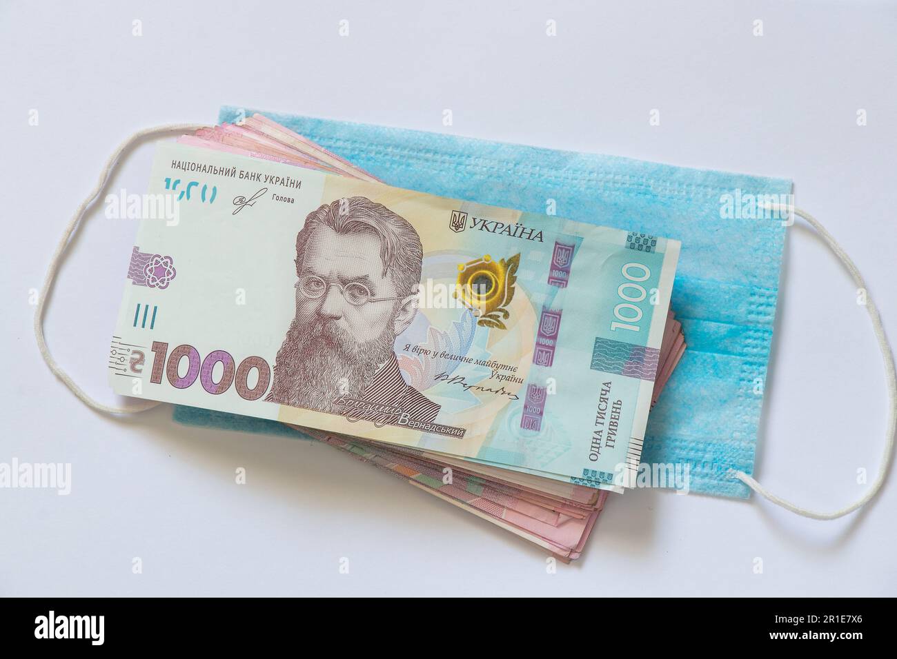 dinero en efectivo y hryvnias y una máscara médica Foto de stock