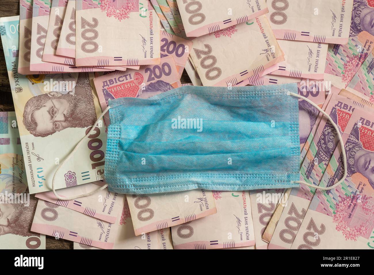 dinero en efectivo y hryvnias y una máscara médica Foto de stock