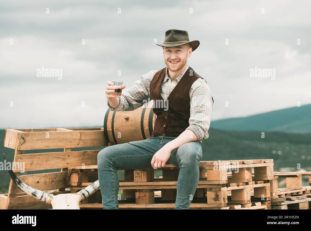 Chico vaquero. Feliz propietario del rancho bebe un whisky