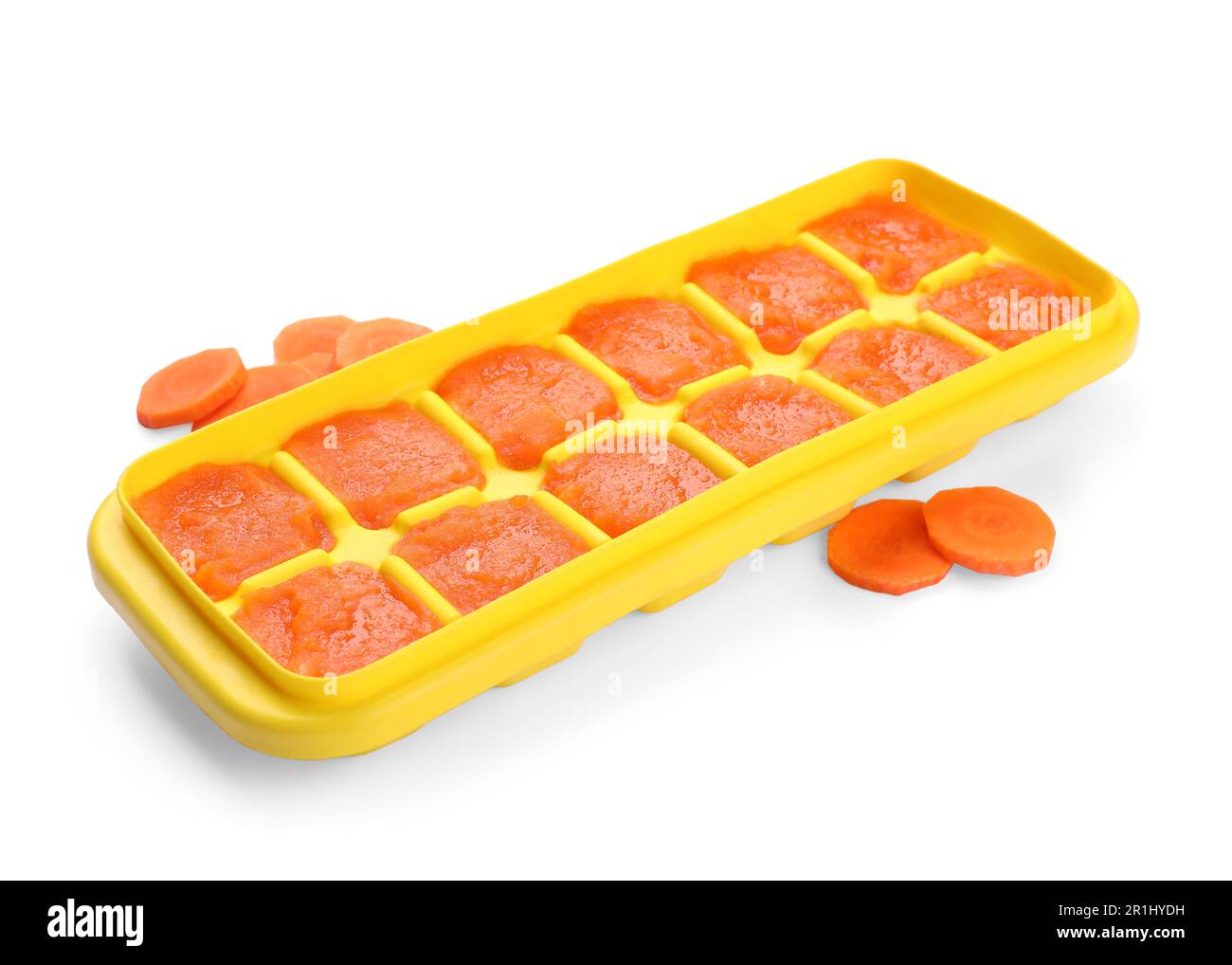 Puré de zanahoria en bandeja de cubitos de hielo aislado en blanco. Listo para congelar Foto de stock