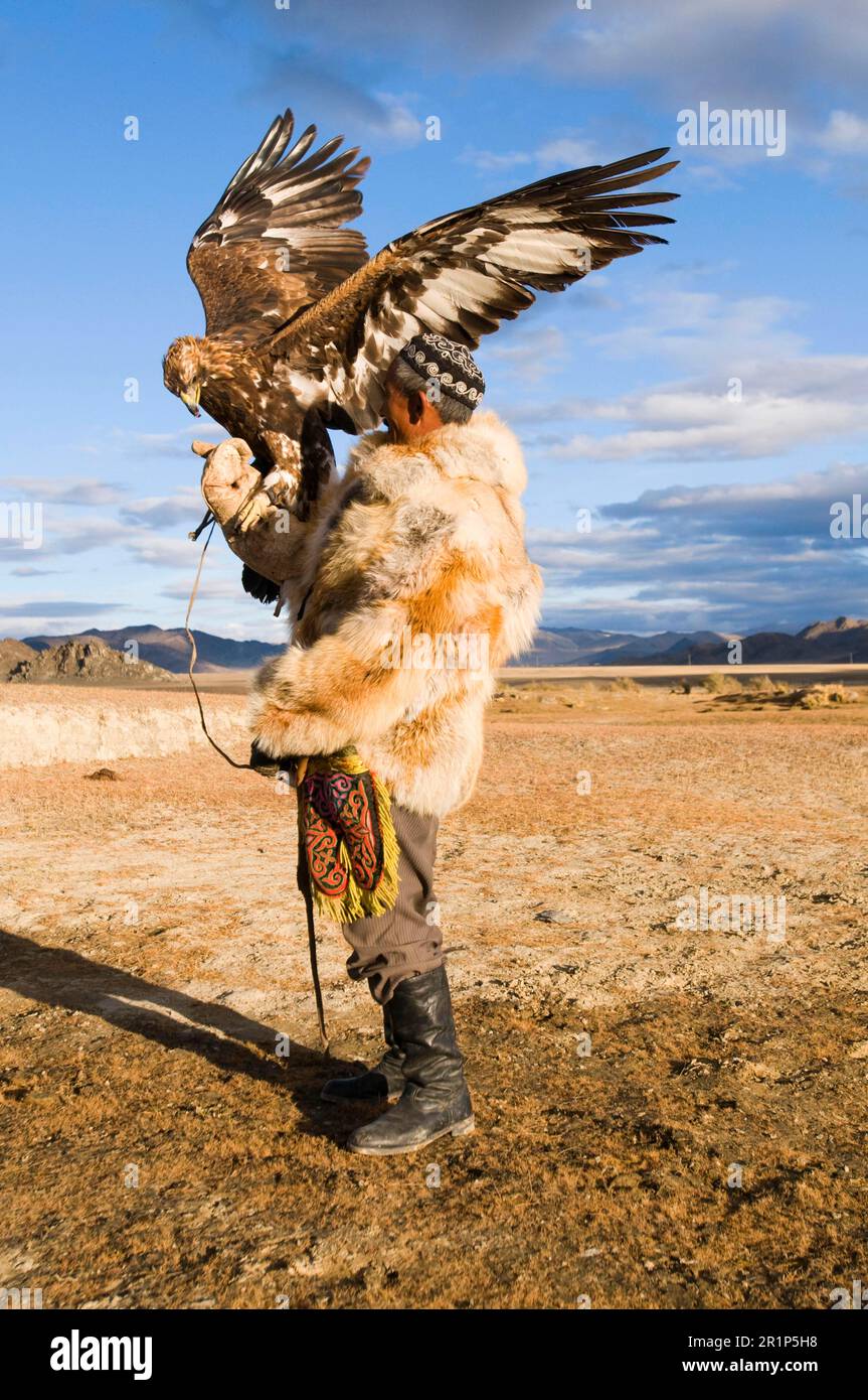 Cazador kazajo con águila dorada (Aquila chrysaetos), montañas Altai, Bayan-Ulgii, Mongolia Occidental Foto de stock