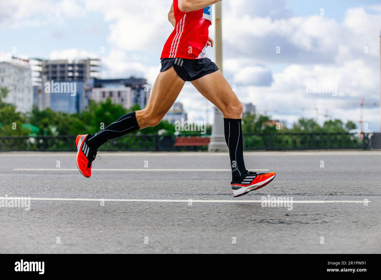 zapatillas de correr, pantalones cortos y carreras singlet, piernas corredor hombre correr maratón en la ciudad, carrera deportiva de Fotografía de Alamy