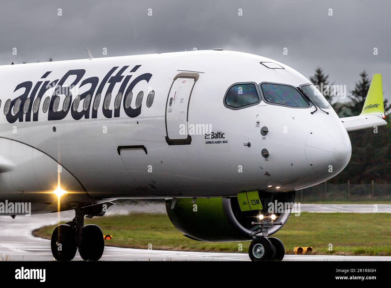 YL-CSM airBaltic Airbus A220 taxies fuera de la pista en el aeropuerto de Edimburgo Foto de stock