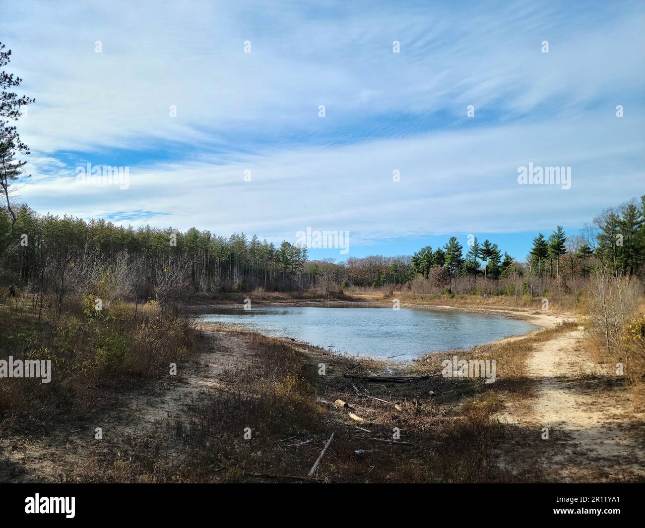 Pequeño lago interior de Michigan con reflejo de cielo azul y sol Foto de stock