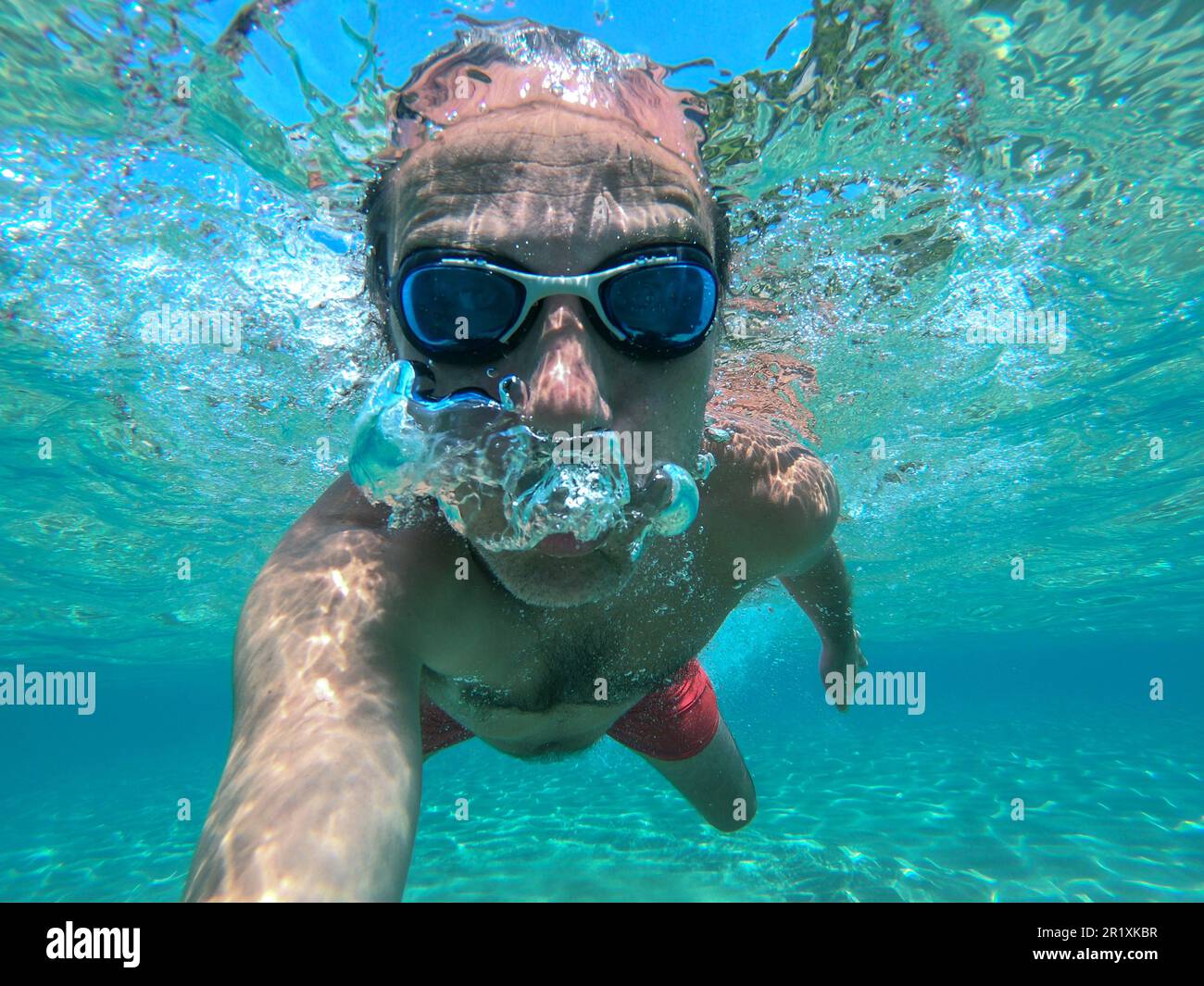 El hombre bucear en la piscina y tomar un selfie con gafas de natación  Fotografía de stock - Alamy