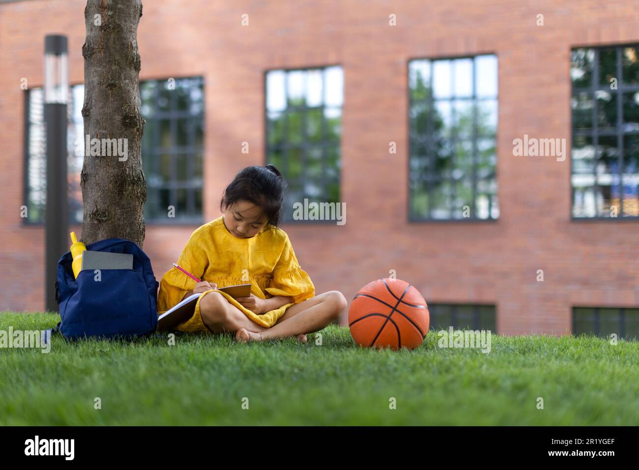 Niña asiática sentada en un parque público y escribiendo notas. Horario de  verano Fotografía de stock - Alamy