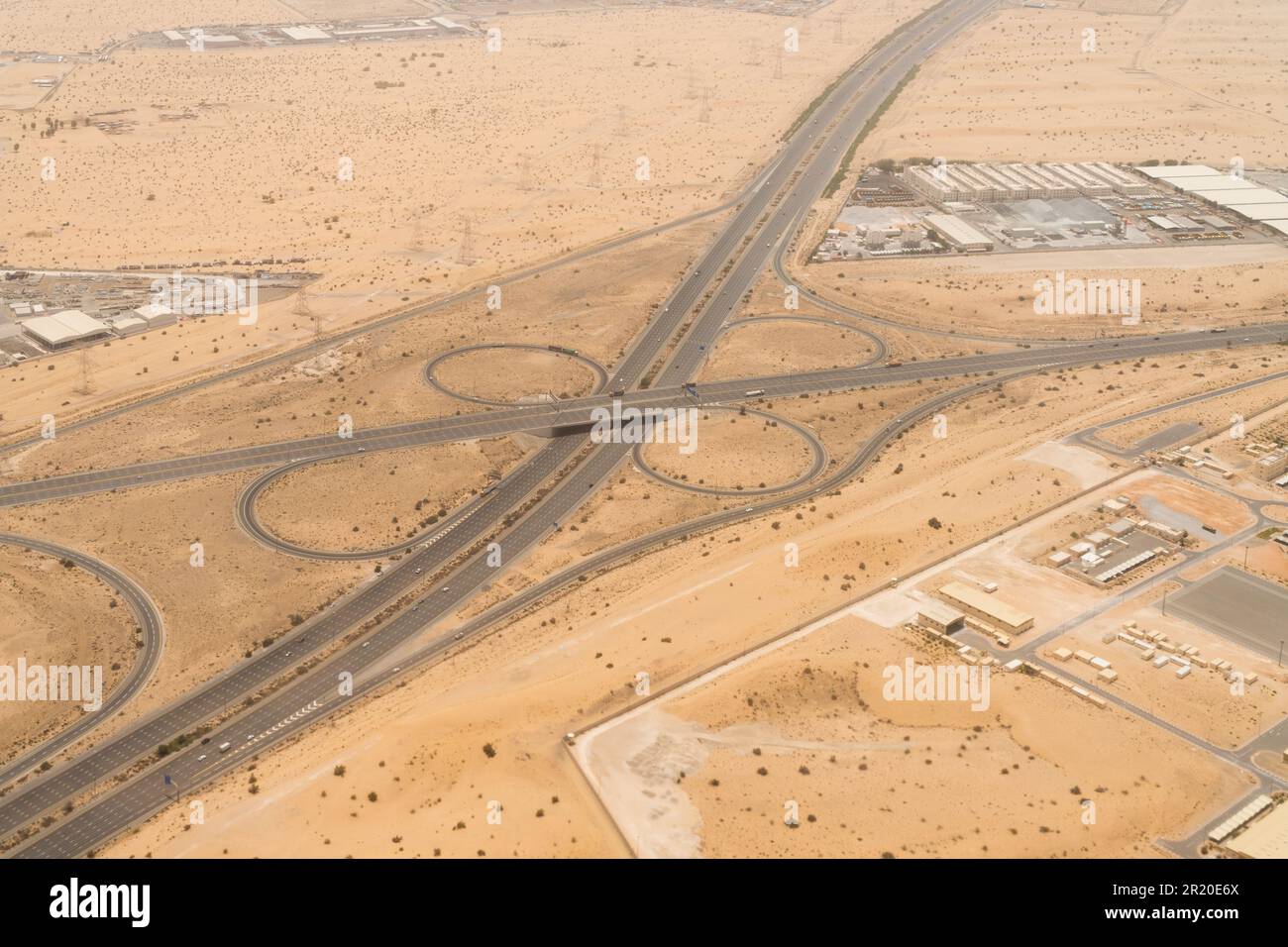 Vista aérea de un día de una carretera con un intercambio elevado en un paisaje desértico en Dubai, Emiratos Árabes Unidos. Foto de stock