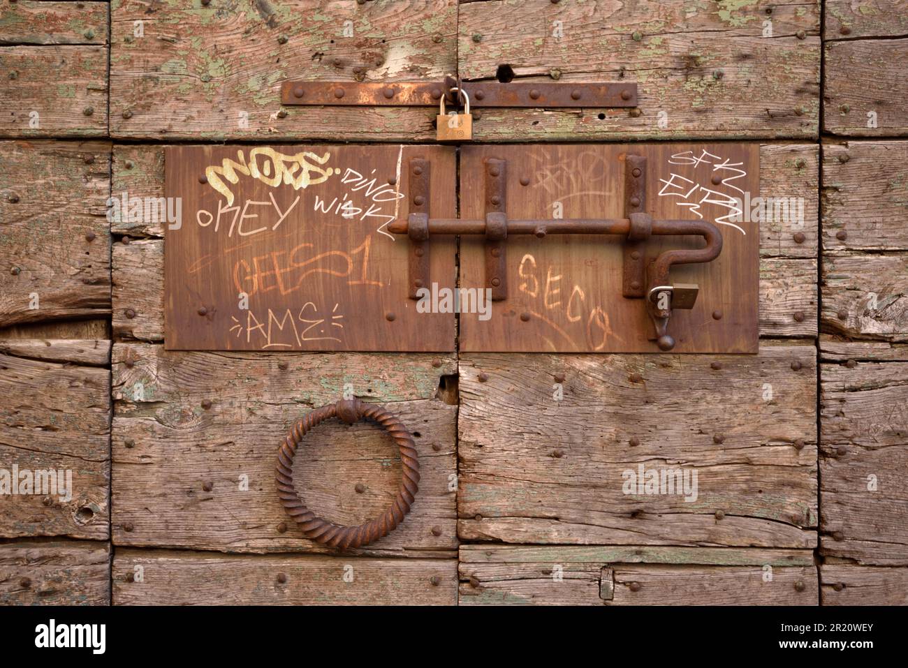 Perno de puerta oxidado, cierre deslizante y candados en la puerta de madera vieja, Trastevere, Roma, Italia Foto de stock