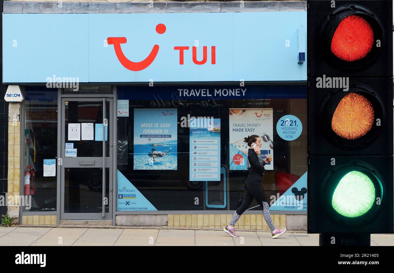 Una mujer pasa por delante de una sucursal de la Agencia de Viajes Tui, cerrada en todo el Reino Unido. La industria de viajes se ha visto duramente afectada por las continuas restricciones del coronavirus y la implementación de un sistema de semáforos en medio de la pandemia de coronavirus COVID-19. Junio de 2021. Foto de stock