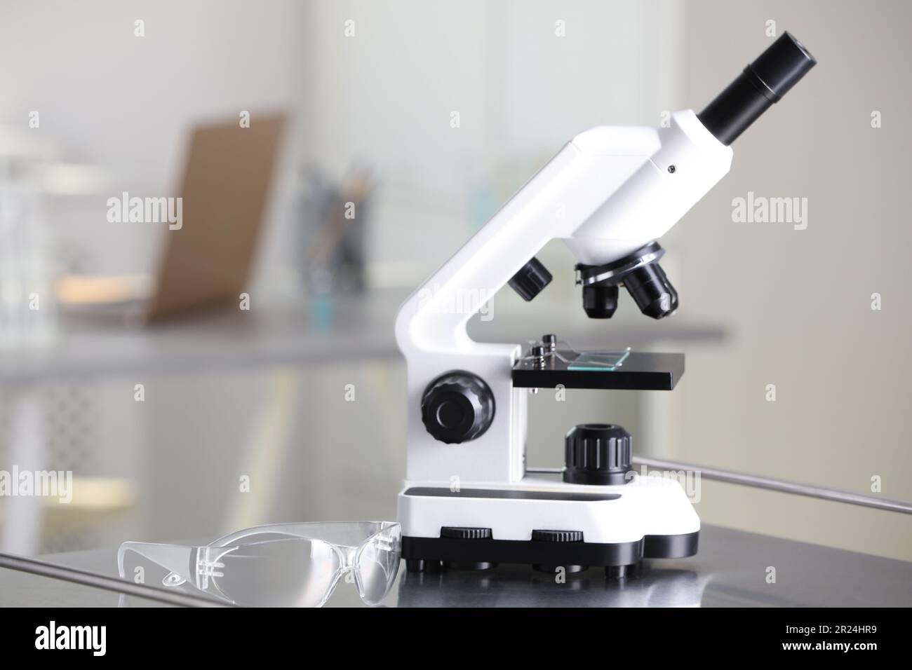 Microscopio moderno con portaobjetos de vidrio en mesa de metal en  laboratorio. Espacio para texto Fotografía de stock - Alamy