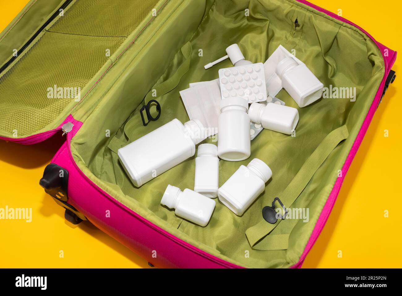 Concepto de seguro de salud de viaje. Viaje maleta rosa, bolsa llena de  medicamentos: Píldoras, botellas de tableta, contenedores, yeso adhesivo,  garganta oruga spray Fotografía de stock - Alamy