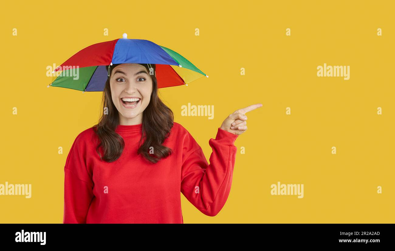 Mujer con sombrilla de cabeza señalando el dedo en el espacio de copia que presenta oferta promocional descuento de temporada Fotografía de stock - Alamy