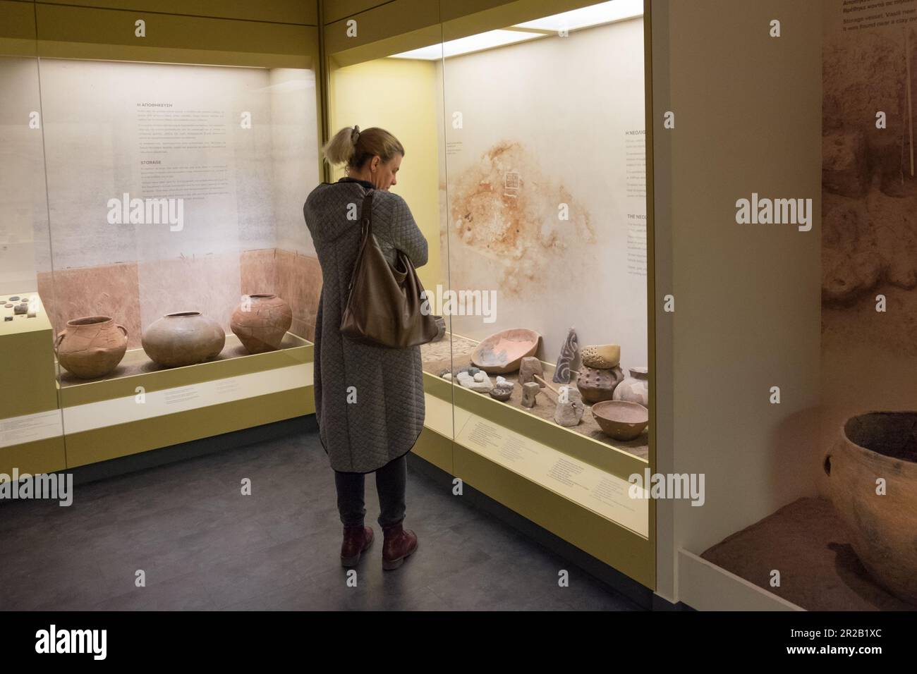 Mujer mirando cuencos de arcilla del período neolítico. Museo Diacrónico de Larissa , Grecia Foto de stock