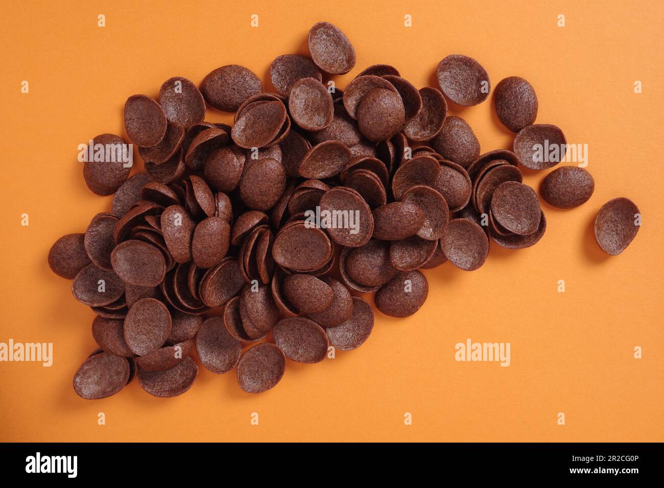 Desayuno de cereales de chocolate sobre fondo naranja. Vista superior Foto de stock