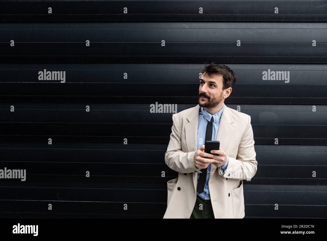 Retrato de joven hombre de negocios fuera del edificio de oficinas experto en negocios globales y marketing, empleado de una empresa para la venta de acciones y. Foto de stock