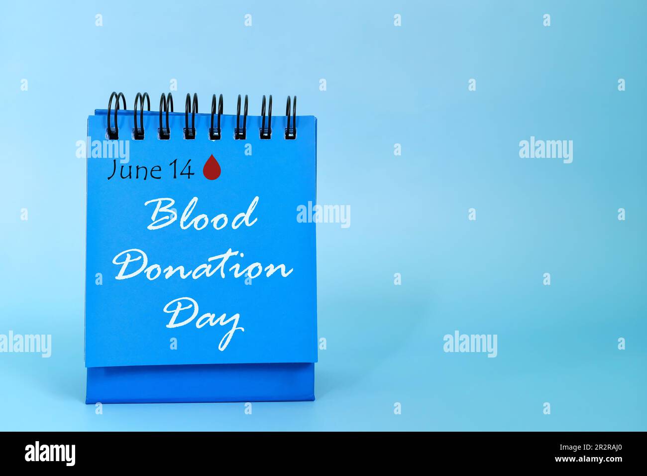 14 de junio como recordatorio de la fecha del Día de la Donación de Sangre en el calendario de escritorio azul. Concepto de celebración. Foto de stock