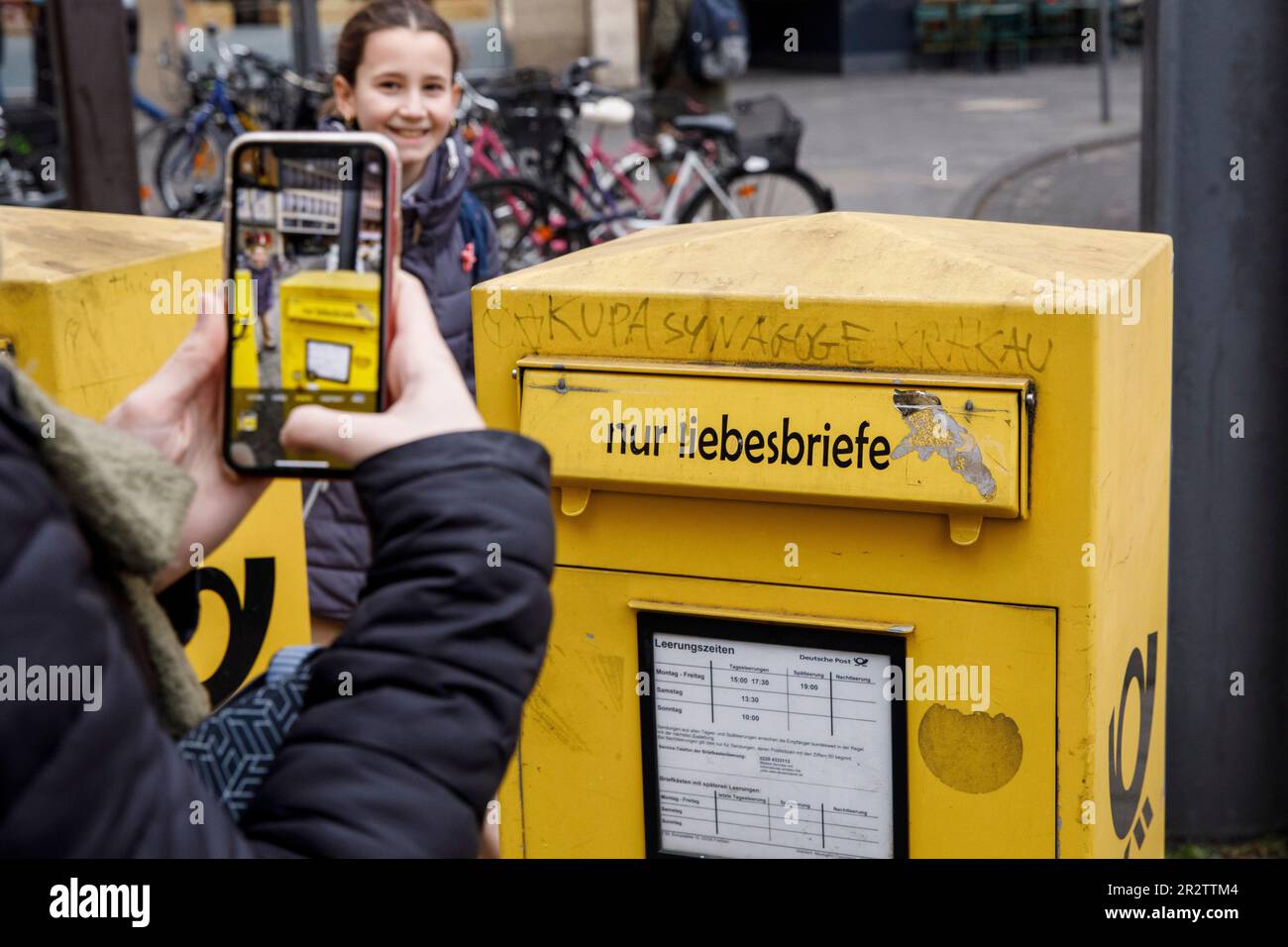 Mujer toma fotos con su teléfono móvil de un buzón solo para cartas de amor en la ciudad, Colonia, Alemania. Frau fotografiert mit einem Handy einen B Foto de stock