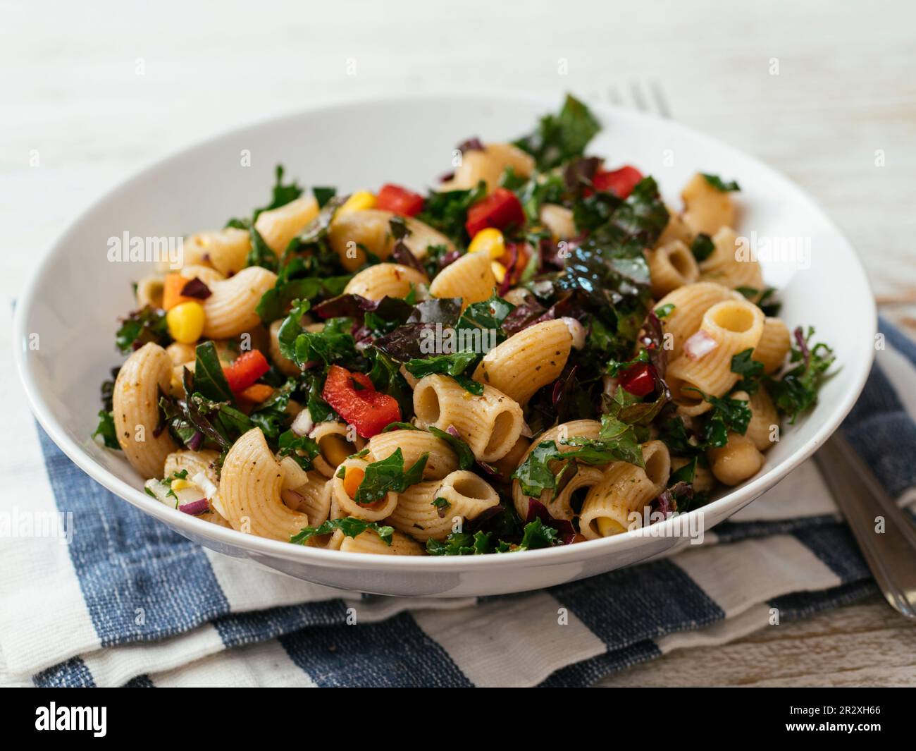 Cuenco con una ensalada casera de pasta kale vegetariana con la variedad de telar 'Rojo Ruso'. Foto de stock