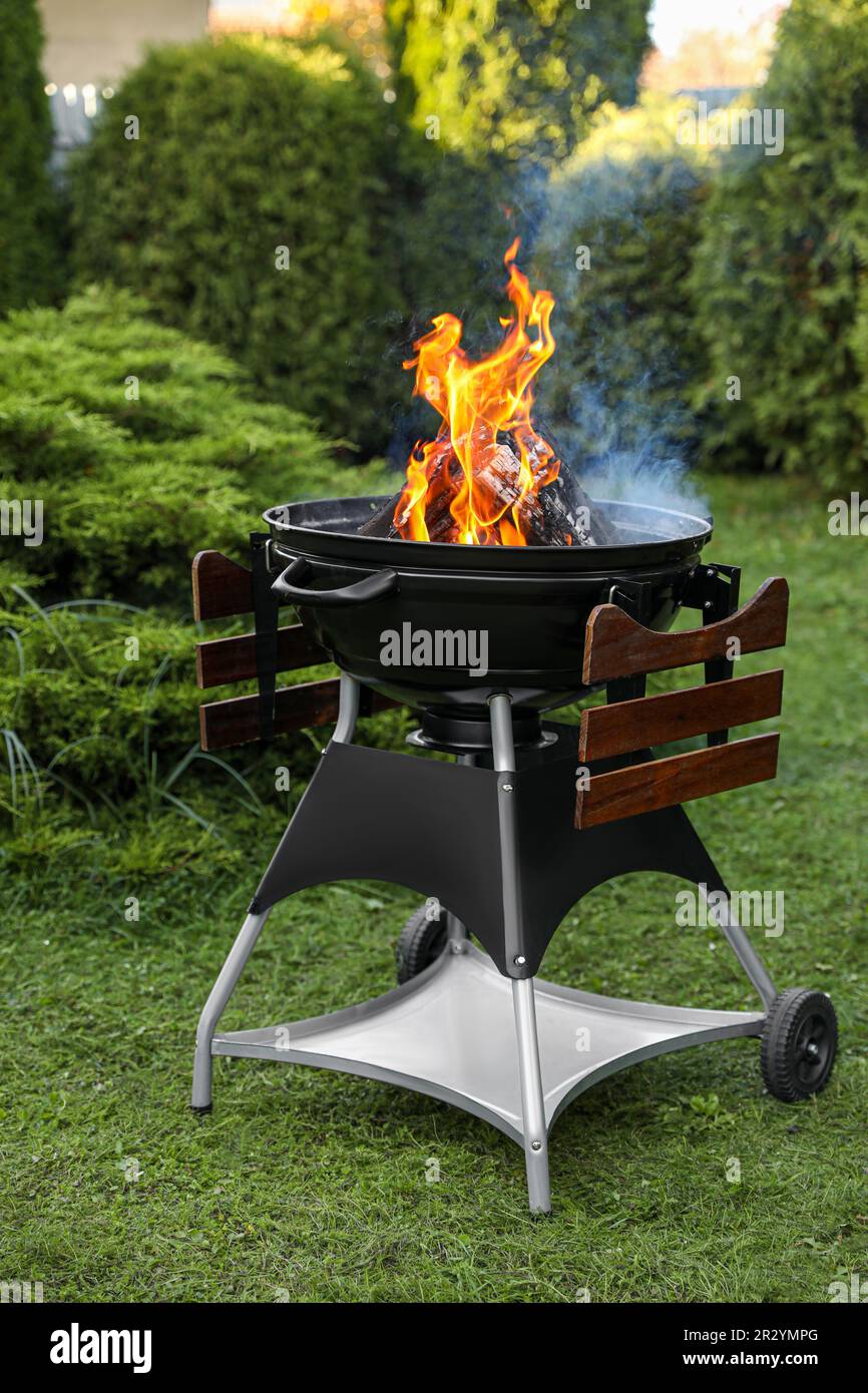 Parrilla de barbacoa portátil con llamas de fuego al aire libre Fotografía  de stock - Alamy
