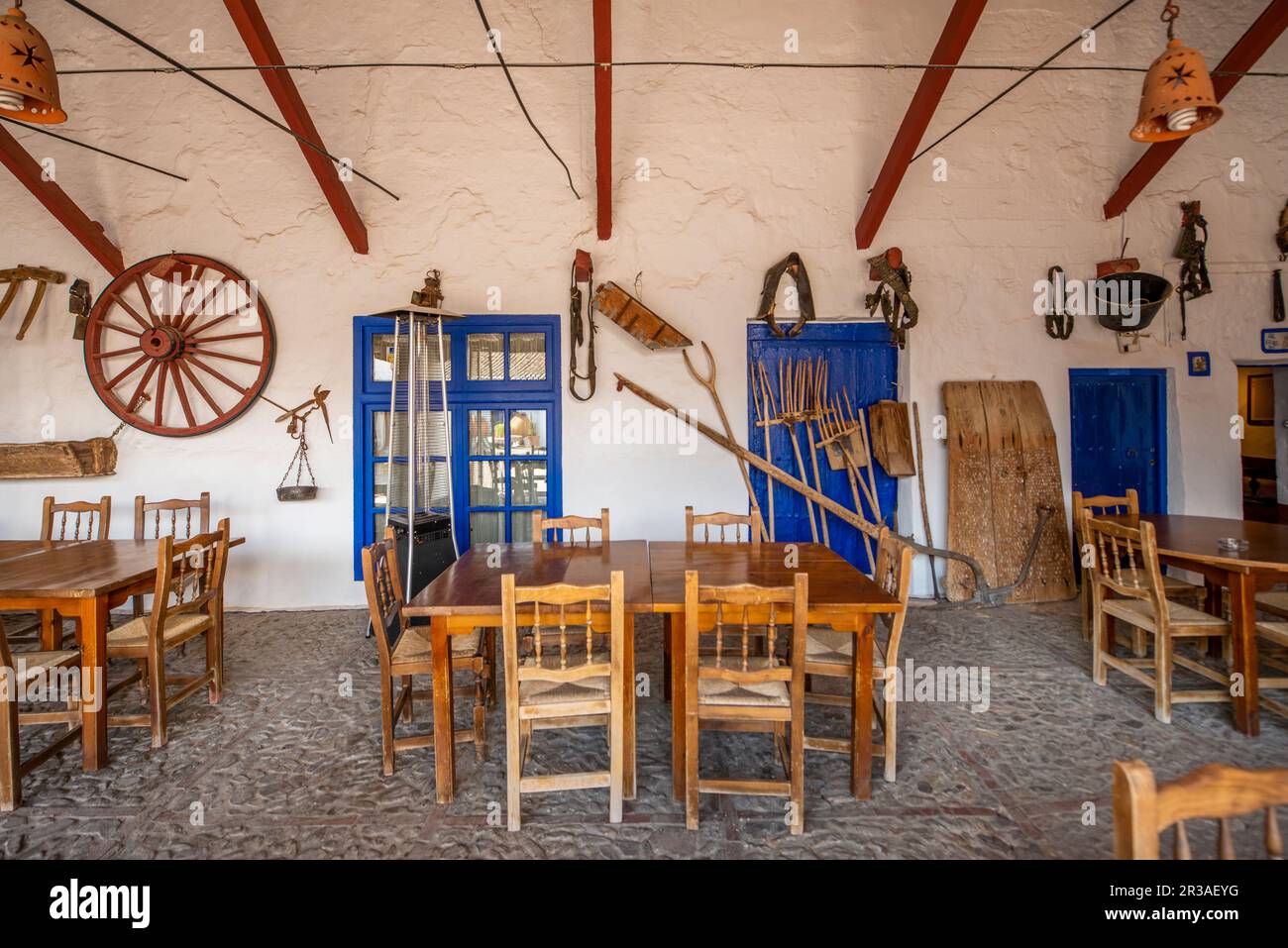 Comedor de una antigua posada de estilo masía histórica en La Mancha, en  España con implementos de granja Fotografía de stock - Alamy