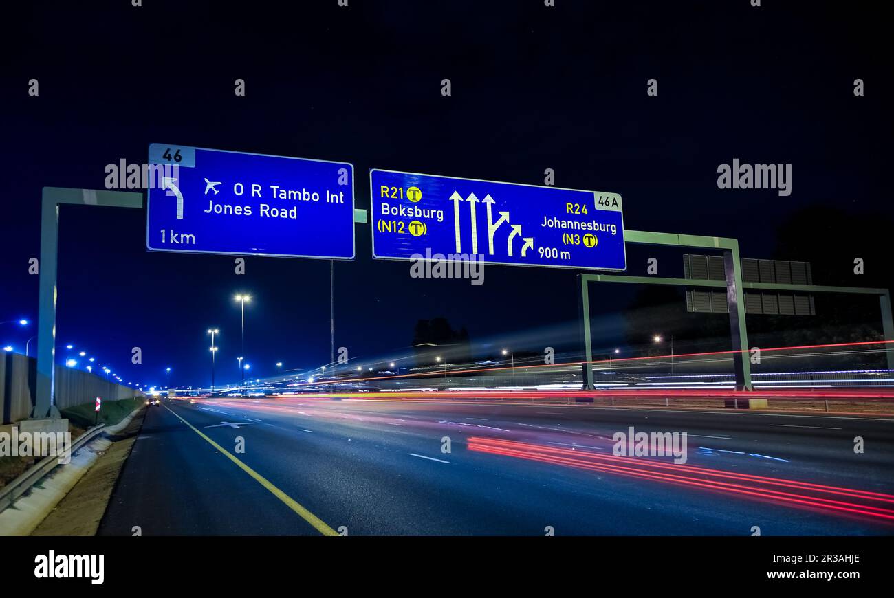 Señales de autopista en la autopista por la noche Foto de stock