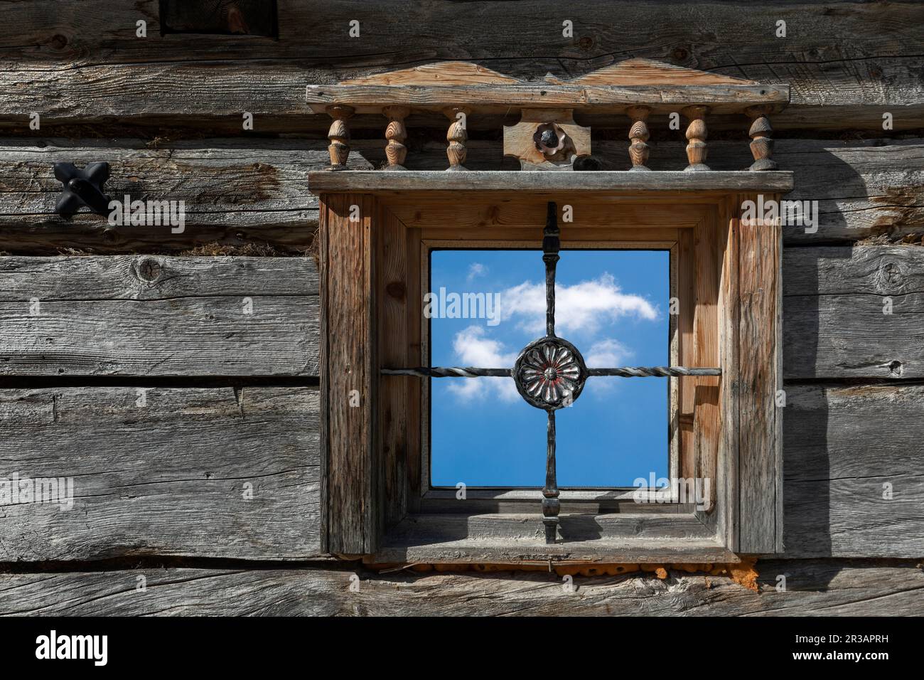 Vieja ventana de madera de cabaña de montaña con cielo y nube Foto de stock