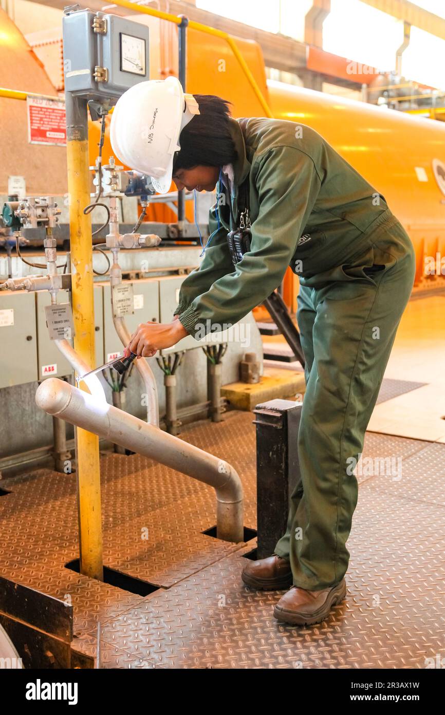 Técnica femenina en la sala de turbinas en la central eléctrica de combustión de carbón Foto de stock