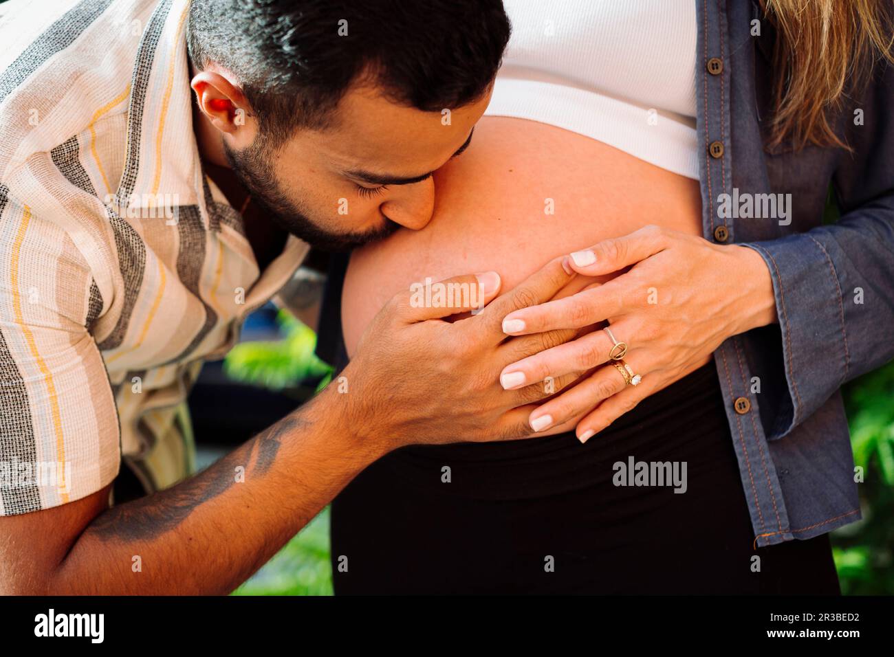 El hombre besando el vientre de la mujer embarazada Foto de stock