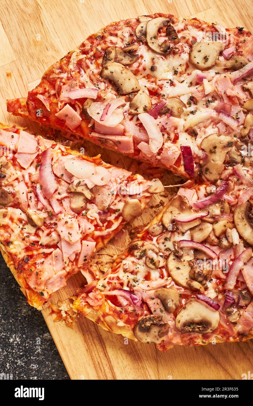 Comida rápida, pizza congelada al horno con jamón, champiñones y queso en  masa espesa. Listo para comer. Diseño plano Fotografía de stock - Alamy