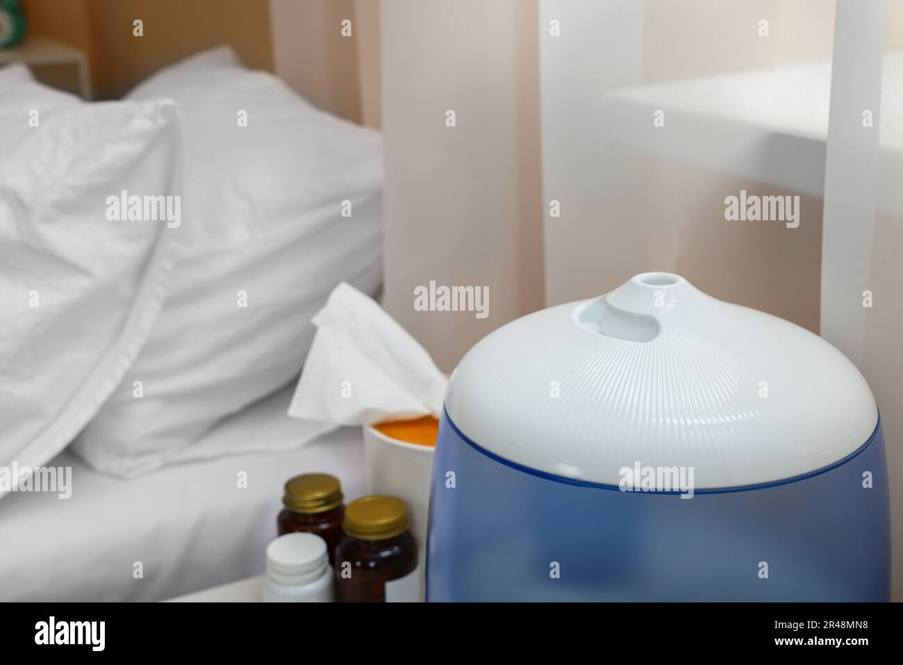 Humidificador de aire, pañuelos y medicamentos cerca de la cama en la  habitación, primer plano. Temporada de gripe Fotografía de stock - Alamy