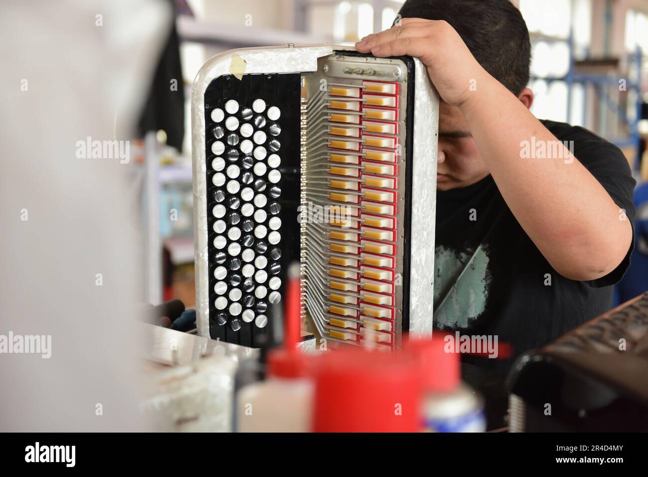 230527) -- TIANJIN, 27 de mayo de 2023 (Xinhua) -- Un trabajador revisa un  acordeón en un taller de Tianjin Yingwu Musical Instrument Co., Ltd. En la  ciudad de Zhongwang del distrito