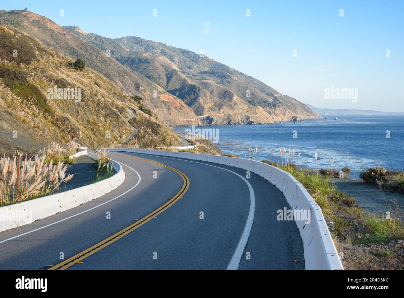 Sinuosa carretera a lo largo de la escarpada costa de California en un claro día de otoño Foto de stock