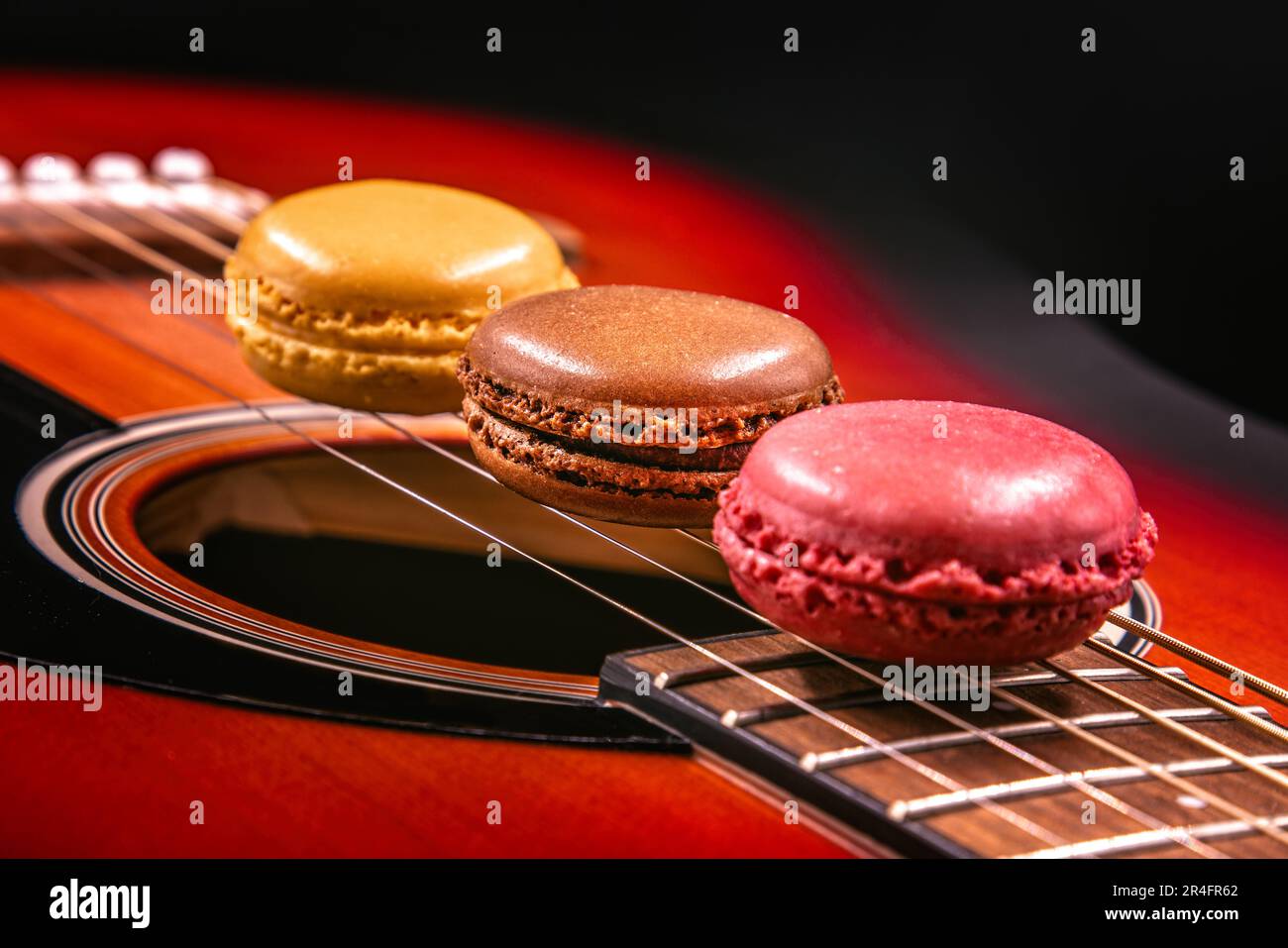 Macarons en una fila en cuerdas de guitarra Foto de stock