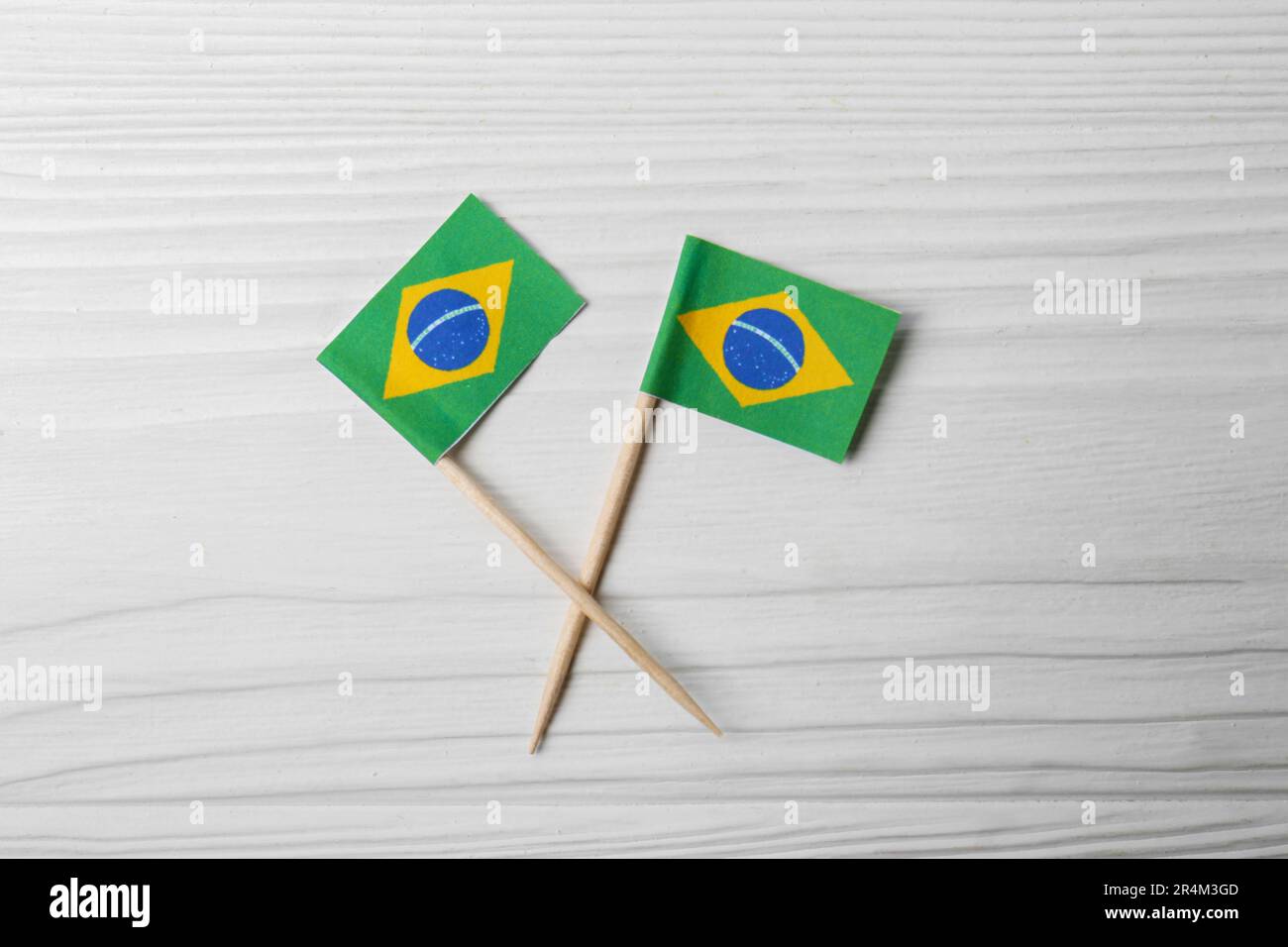 Pequeñas banderas de papel de Brasil en mesa de madera blanca, plana Foto de stock