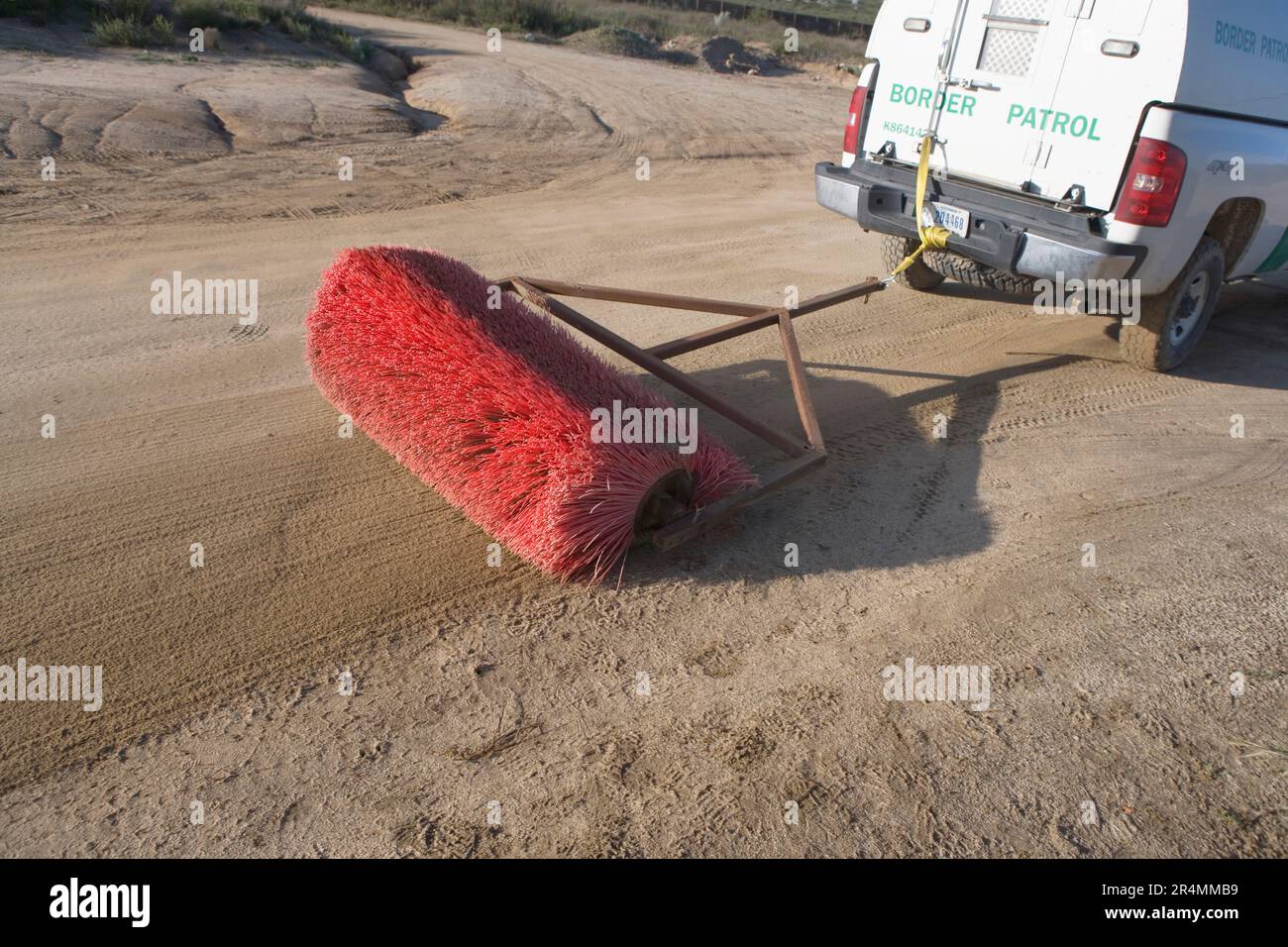 UN EE.UU El vehículo de la Patrulla Fronteriza tira de una escoba para suavizar el suelo a lo largo de la frontera de California, México. Foto de stock