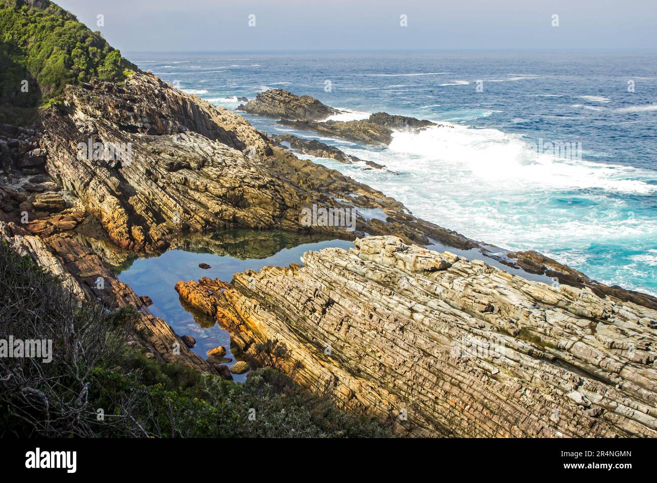 Mirando hacia abajo a una tranquila piscina de roca, a lo largo de la costa rocosa, en Garden Route, Sudáfrica Foto de stock