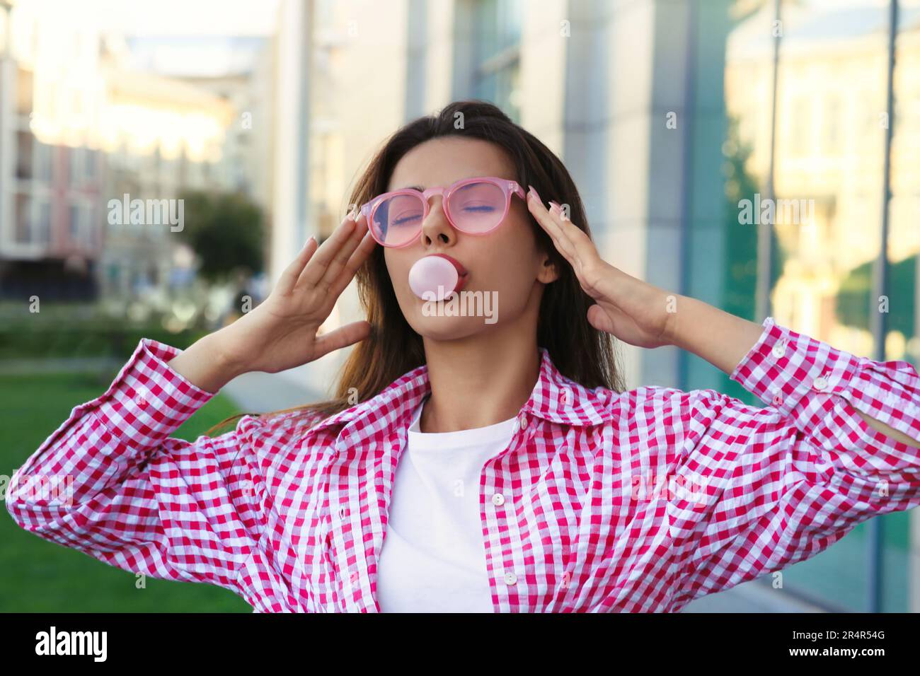 Hermosa mujer en camisa soplando chicle al aire libre Fotografía de stock -  Alamy