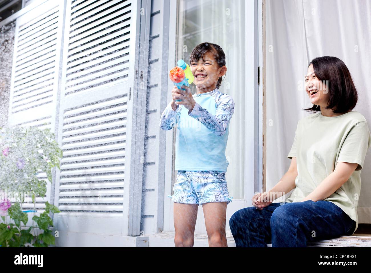 Niño japonés jugando con pistola de agua Foto de stock