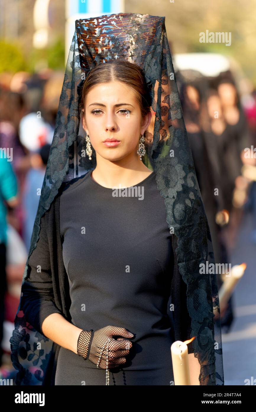 Andalucía España. Procesión en la Semana Santa de Granada. Mujer que usa mantilla (vestido negro) y peineta (peine alto) Foto de stock