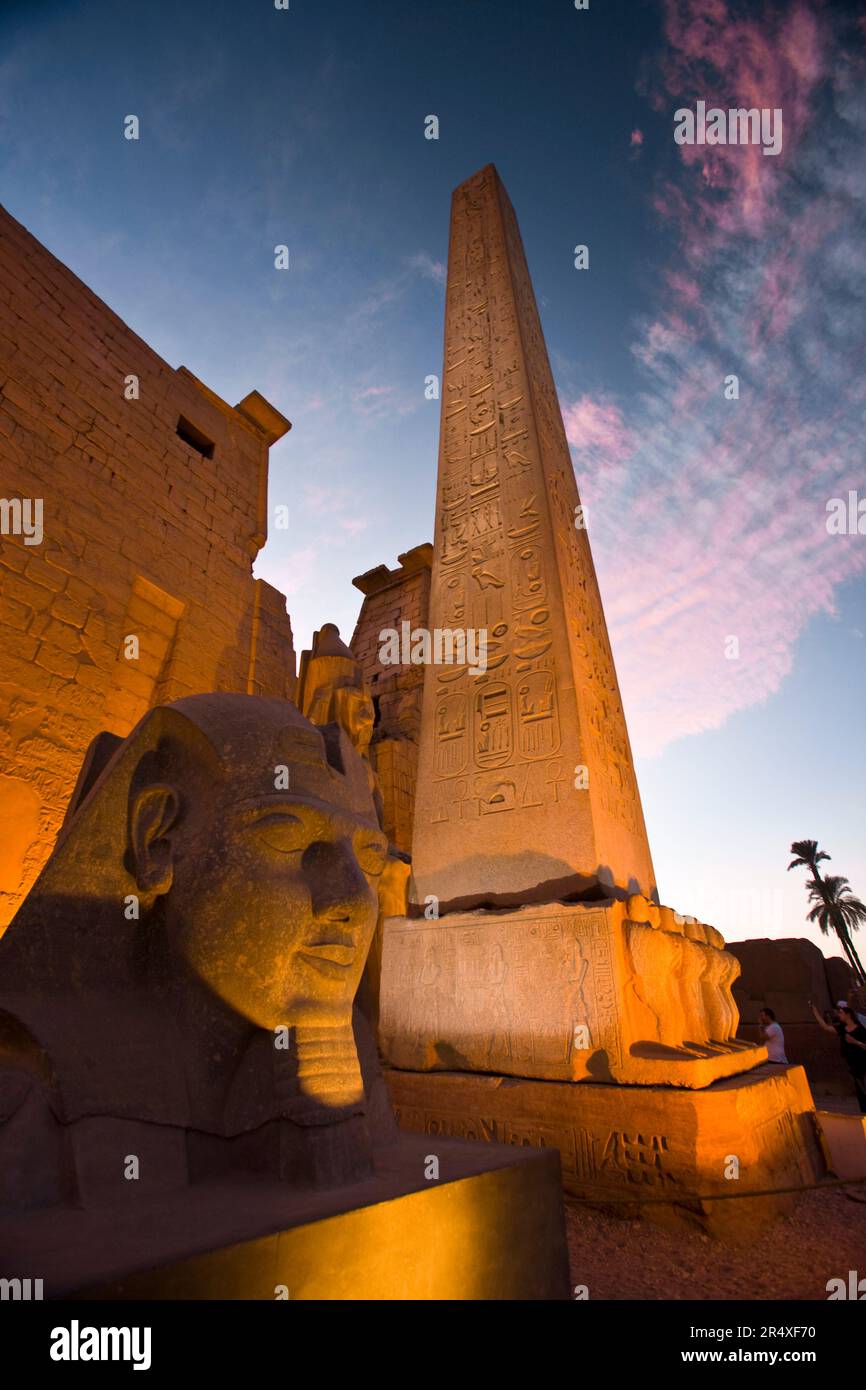 Un obelisco y cabeza de la Esfinge en la entrada al Templo de Luxor. Foto de stock